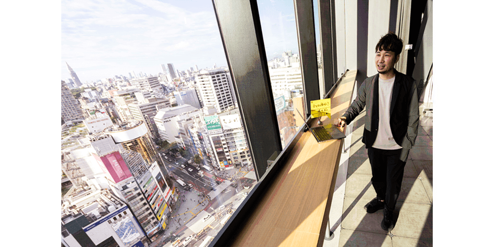 「渋谷から世界へ問いかける、可能性の交差点」SHIBUYA QWS(渋谷キューズ)を主な仕事場にしている横石氏。眼下にSSUの舞台となる渋谷の街を見渡せる。